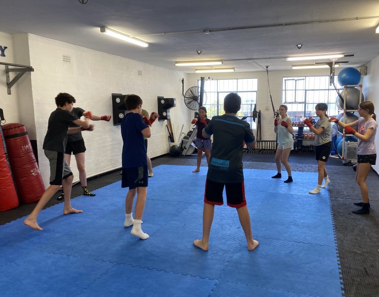 non contact boxing for teens. Pictured teens in a circle practicing boxing drills